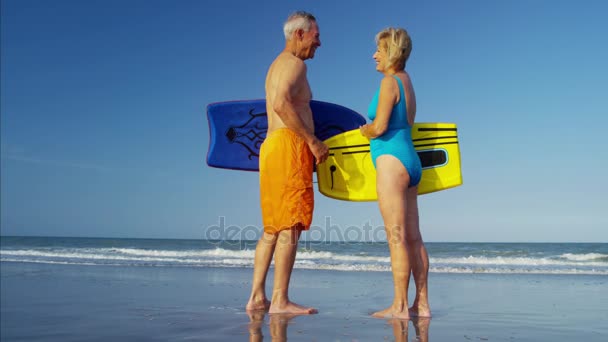 Pareja con body boards en la playa — Vídeo de stock