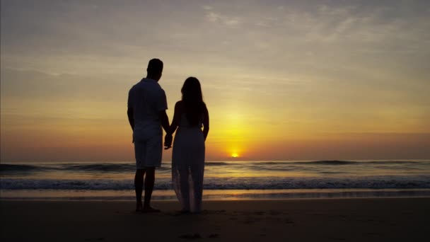 Pár, kteří požívají východ slunce na pláži — Stock video