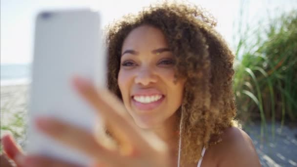 Hembra en la playa con un teléfono inteligente — Vídeos de Stock