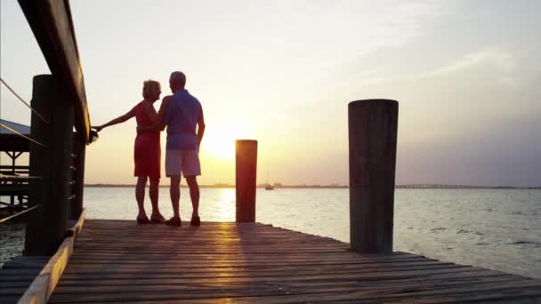 Пара насолоджується схід сонця на пірсі — стокове відео