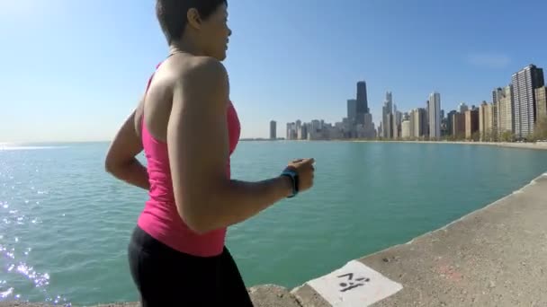 Жінка біжить береговою лінією — стокове відео