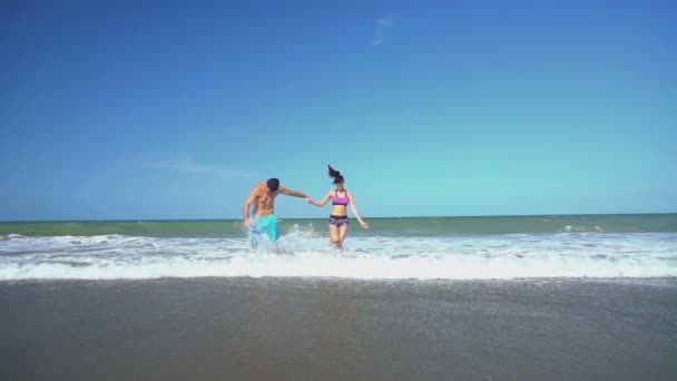 Maschio e femmina che corrono sulla spiaggia — Video Stock