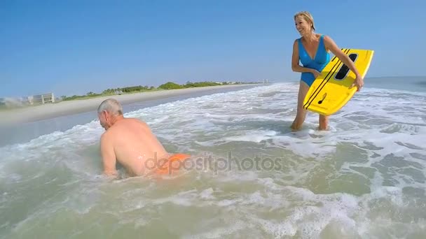 Couple having fun with bodyboards — Stock Video