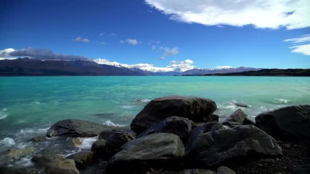 Vågorna över klippor på stranden av Lake Tekapo — Stockvideo