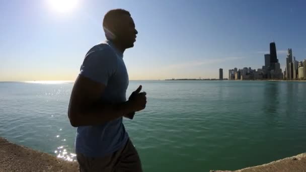 Male running along Chicago shoreline — Stock Video