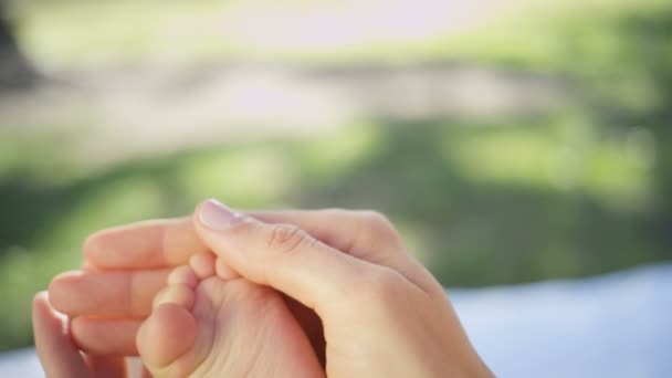 Madres manos acunando el pie del bebé — Vídeo de stock