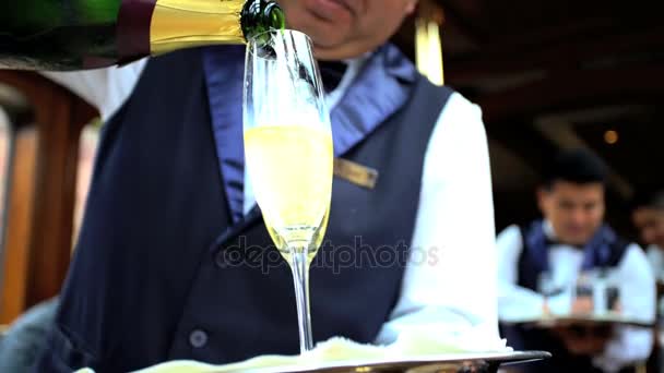 Официант подает шампанское в вагоне-ресторане — стоковое видео