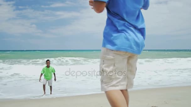 Garçons jouant au ballon sur la plage — Video