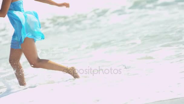 Девушка бежит по волнам на пляже — стоковое видео