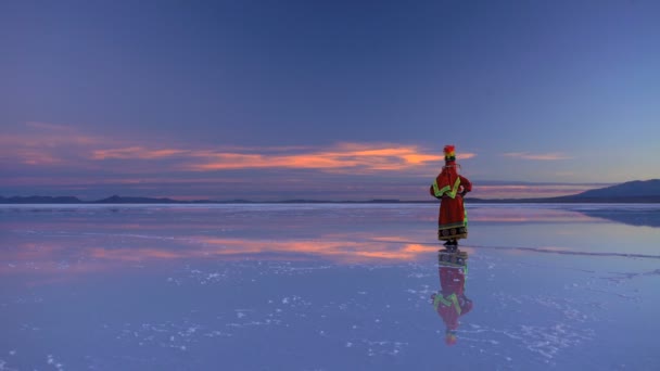 Mulher ao nascer do sol andando sobre o Salar de Uyuni — Vídeo de Stock