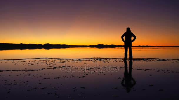 Turist tittar på solnedgången på Salar de Uyuni — Stockvideo