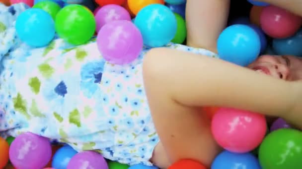 Fille jouer dans la piscine boules pleines — Video