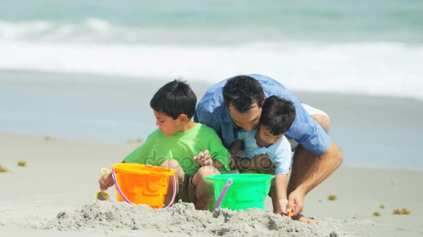 Pai e seus filhos fazendo castelos de areia — Vídeo de Stock