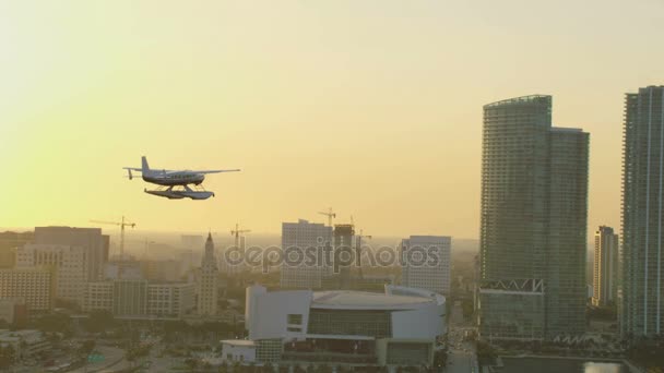 Zonsondergang van watervliegtuig vliegen over de stad — Stockvideo