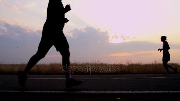 Corredores en el trabajo de carretera a la salida del sol — Vídeos de Stock