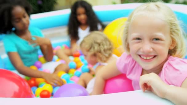 Девушка играет с друзьями в бассейне с мячом — стоковое видео