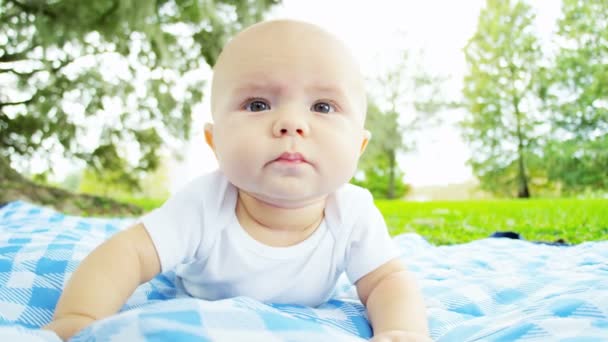 Niño acostado en la manta al aire libre — Vídeos de Stock