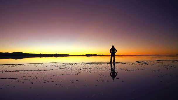Turist tittar på solnedgången på Salar de Uyuni — Stockvideo