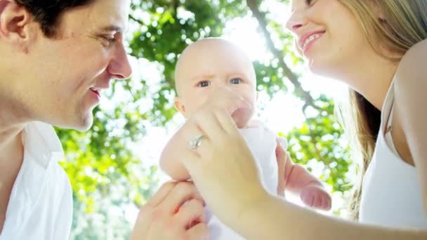 Bebé con padres besándola — Vídeo de stock