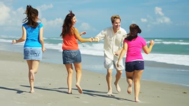 Family running barefoot by the water — Stock Video