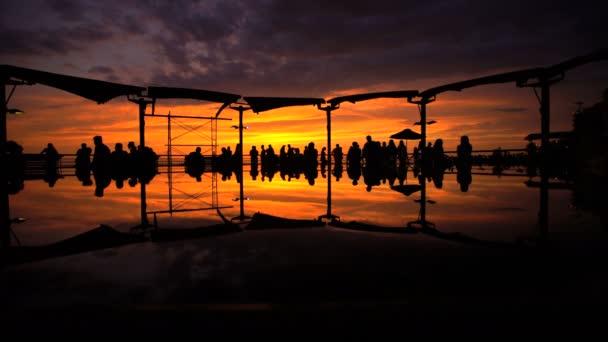 Люди смотрят на золотой закат в Ларкомаре — стоковое видео