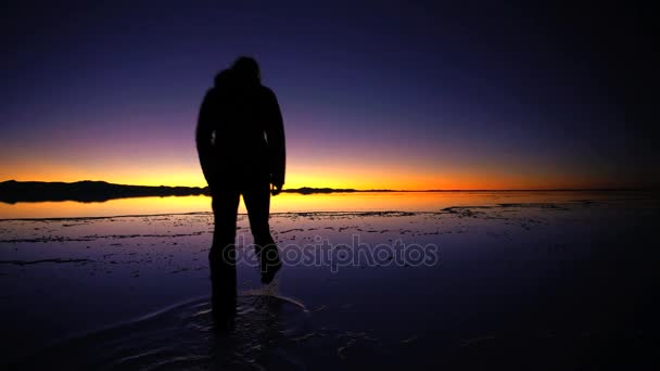 Turist på sunrise visning Salar de Uyuni — Stockvideo