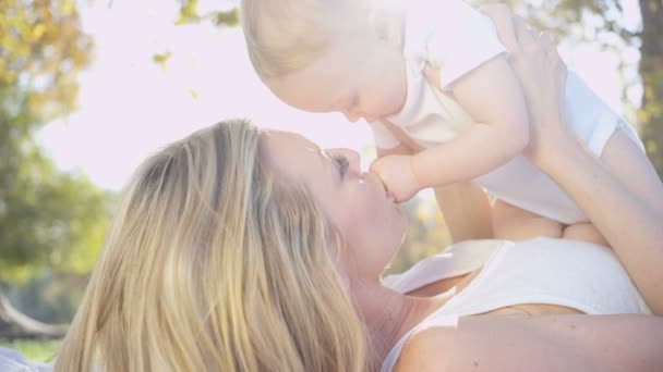 Мама целует своего маленького ребенка — стоковое видео