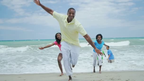 Family enjoying waves on the beach — Stock Video