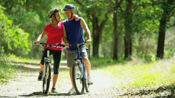 Pareja ciclismo en el bosque — Vídeos de Stock