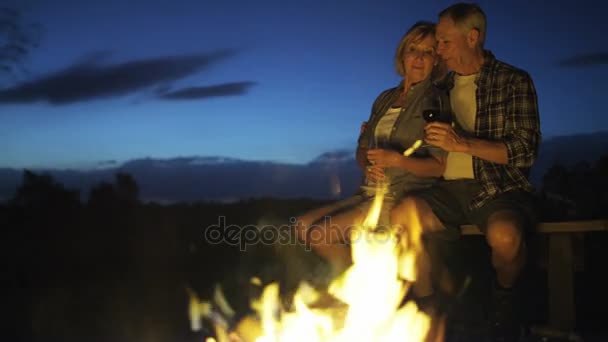 Senioren sitzen am Lagerfeuer — Stockvideo