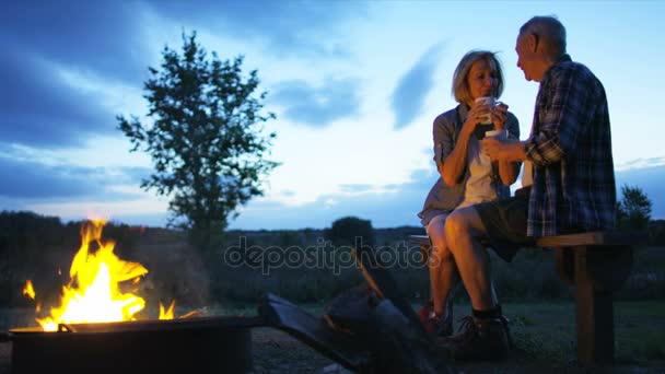 キャンプファイヤーで座っているカップル — ストック動画