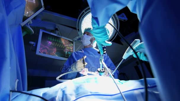 Хирургическая команда, выполняющая лапароскопическую операцию — стоковое видео
