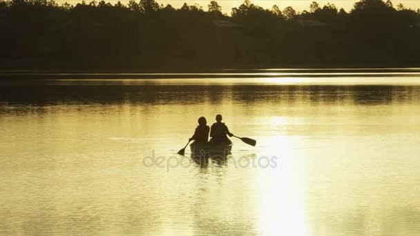 Старшеклассники на байдарках по озеру — стоковое видео