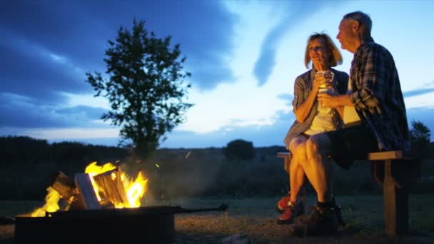 Paar sitzt am Lagerfeuer — Stockvideo