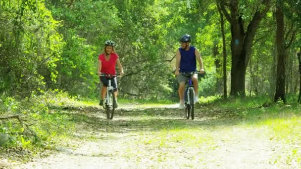 Pareja disfrutando del ciclismo en el bosque — Vídeo de stock