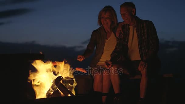Ζευγάρι μαγείρεμα λουκάνικα πάνω από ένα campfire — Αρχείο Βίντεο