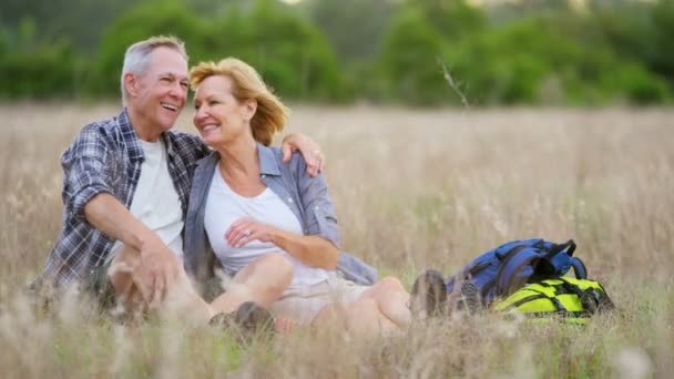 Senioren die rust in het veld — Stockvideo