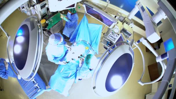 Команда, выполняющая операцию по лапароскопии — стоковое видео
