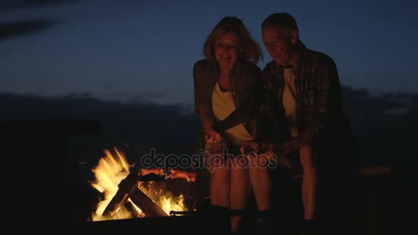 Ζευγάρι μαγείρεμα λουκάνικα πάνω από ένα campfire — Αρχείο Βίντεο
