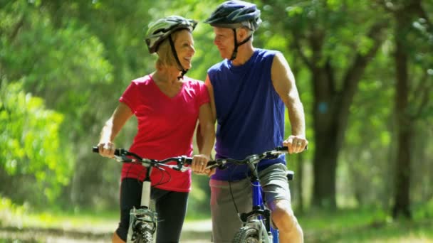 Пара наслаждается езды на велосипеде в парке — стоковое видео