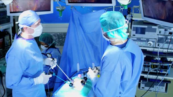 Хирургическая команда, выполняющая лапароскопическую операцию — стоковое видео