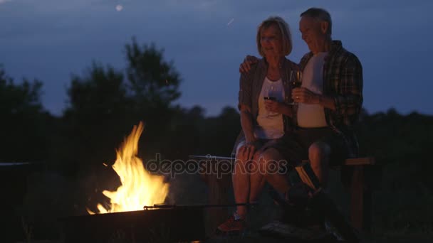 Anziani seduti vicino alle fiamme — Video Stock