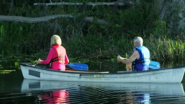 Пара, путешествующая на каяке по озеру — стоковое видео