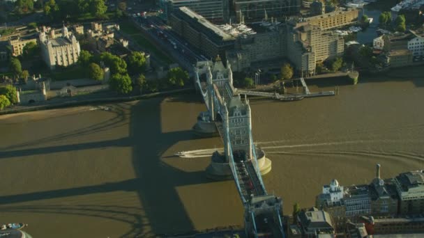 ロンドン イングランド イギリスを渡るタワー ブリッジ テムズ川通勤車両の下で巡航日の出ボートで空撮 — ストック動画