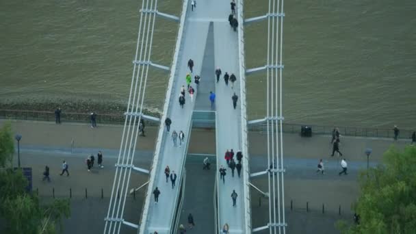 ミレニアム橋鋼懸濁液の歩道橋イギリスのテムズ川を渡る日没の歩行者でビュー間近で航空 — ストック動画