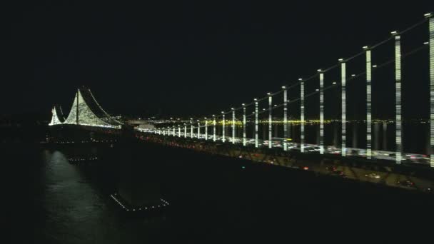 空中夜オークランド湾橋私たち 高速道路 サンフランシスコの街の明かりと米国カリフォルニアの高層ビルに通勤交通ダブルの照らされた街の景色が飾られて — ストック動画