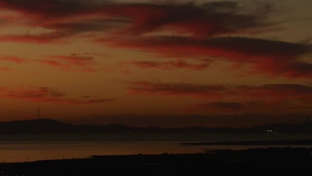 空中の赤い夕焼け空観遠くサンフランシスコ市高層ビル オークランド ブリッジ私たち とオークランド港ドック カリフォルニア州アメリカ合衆国 — ストック動画
