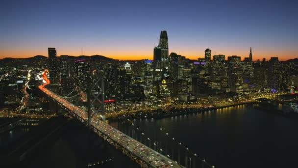 オークランド湾橋私たち 高速道路通勤交通サンフランシスコ ダウンタウン高層のビル カリフォルニア アメリカのサンフランシスコ 2017年 空中夜点灯表示 — ストック動画