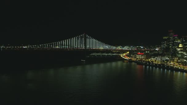 空中海滨夜景照亮旧金山港口恩巴克德罗市中心海湾大桥城市道路建筑办公室摩天大楼渡轮码头加利福尼亚美国 — 图库视频影像