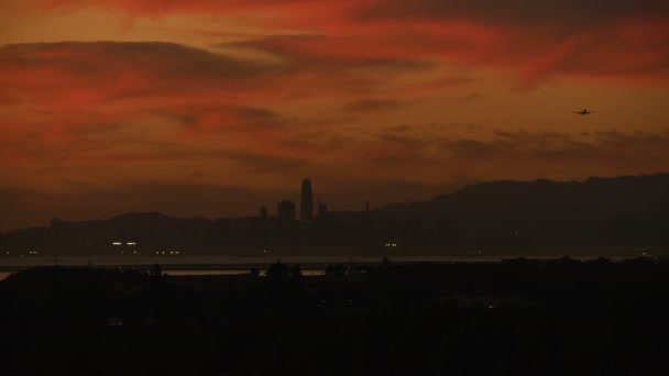 空中の赤い夕焼け空観遠くサンフランシスコ市高層ビル オークランド ブリッジ私たち とオークランド港ドック カリフォルニア州アメリカ合衆国 — ストック動画